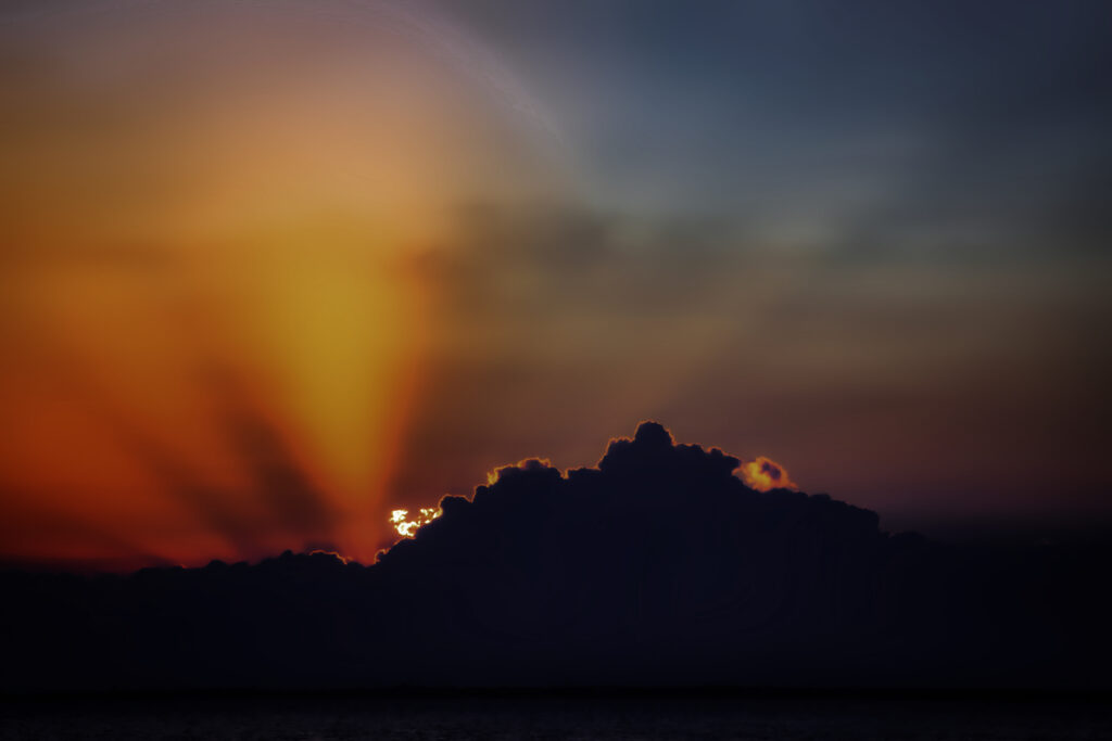 Vibrant sunset wallpaper with bold orange red and blue clouds creating a serene sky background