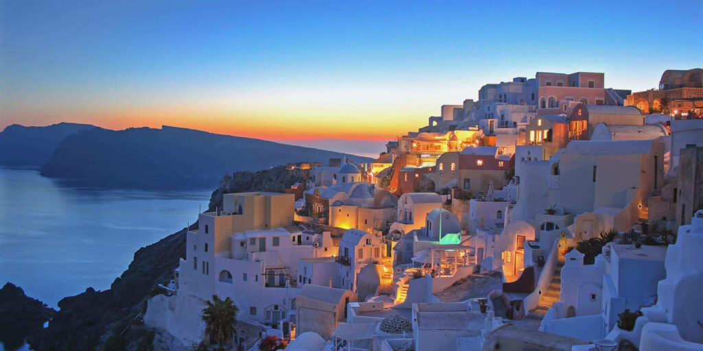 Sunset in Thera, Greece: Iconic Whitewashed Buildings & Aegean Sea Wallpaper