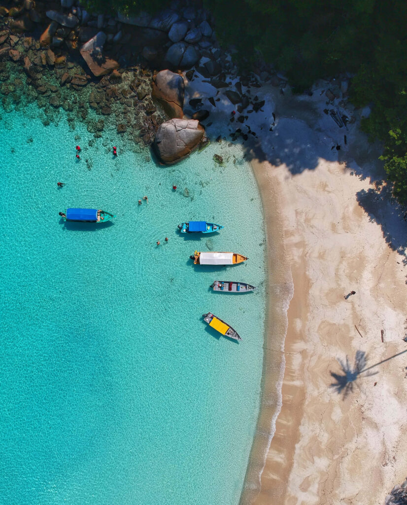 Stunning Aerial Beach View with Clear Waters & Vibrant Boats Wallpaper