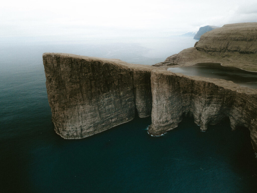 Breathtaking Vágur Island Wallpaper: Rugged Cliffs & Serene Waters