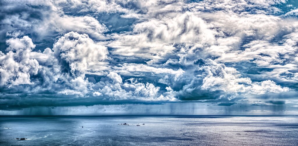 Breathtaking sea view with dramatic textured clouds and calming blue and white tones wallpaper