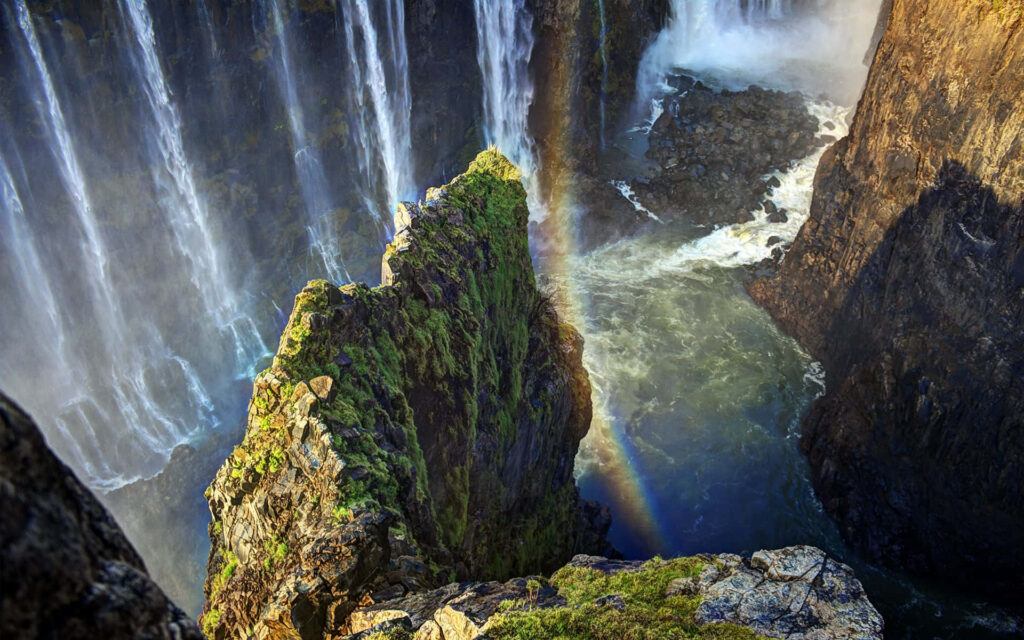 Stunning Victoria Falls Rainbow: Cascading Water & Lush Cliffs Wallpaper