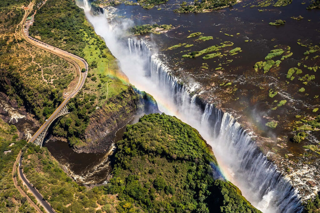 Stunning Victoria Falls Wallpaper with Rainbow and Lush Greenery