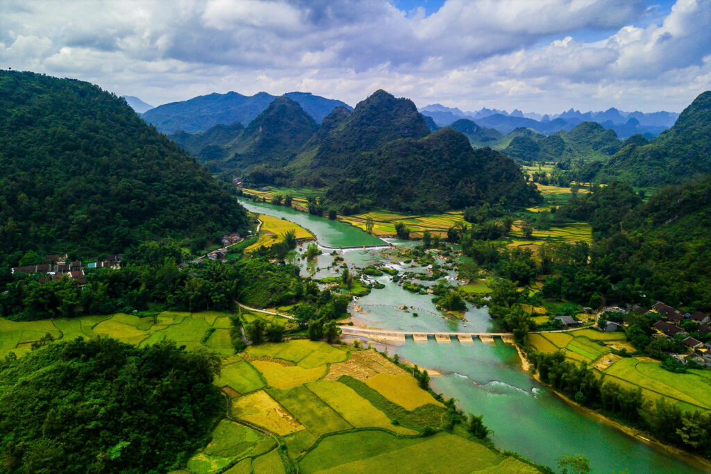 Aerial view of Vietnam Cao Bang Geopark rice fields rivers and limestone mountains under blue sky Wallpaper