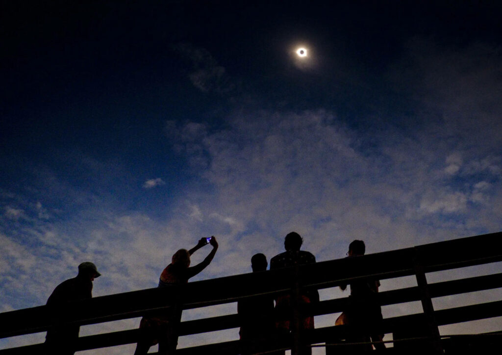 Stunning Bridge Crowd Silhouette Wallpaper: Solar Eclipse Scene