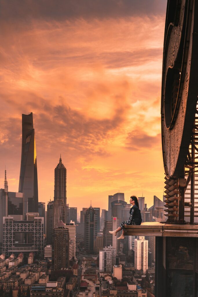 Stunning Sunset Wallpaper: Girl on Roof Overlooking Skyscrapers