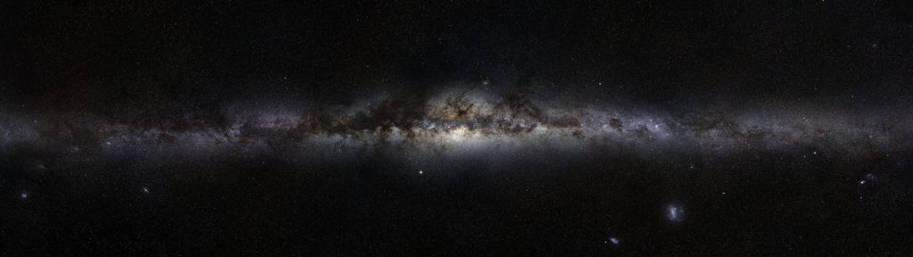 Widescreen Milky Way galaxy wallpaper showing dense glowing core and dark dust lanes in space