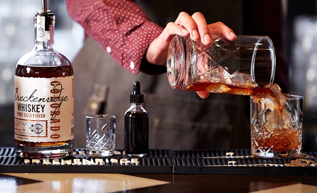Bartender pouring Breckenridge Whiskey cocktail in stylish bar with elegant glassware and tools Wallpaper