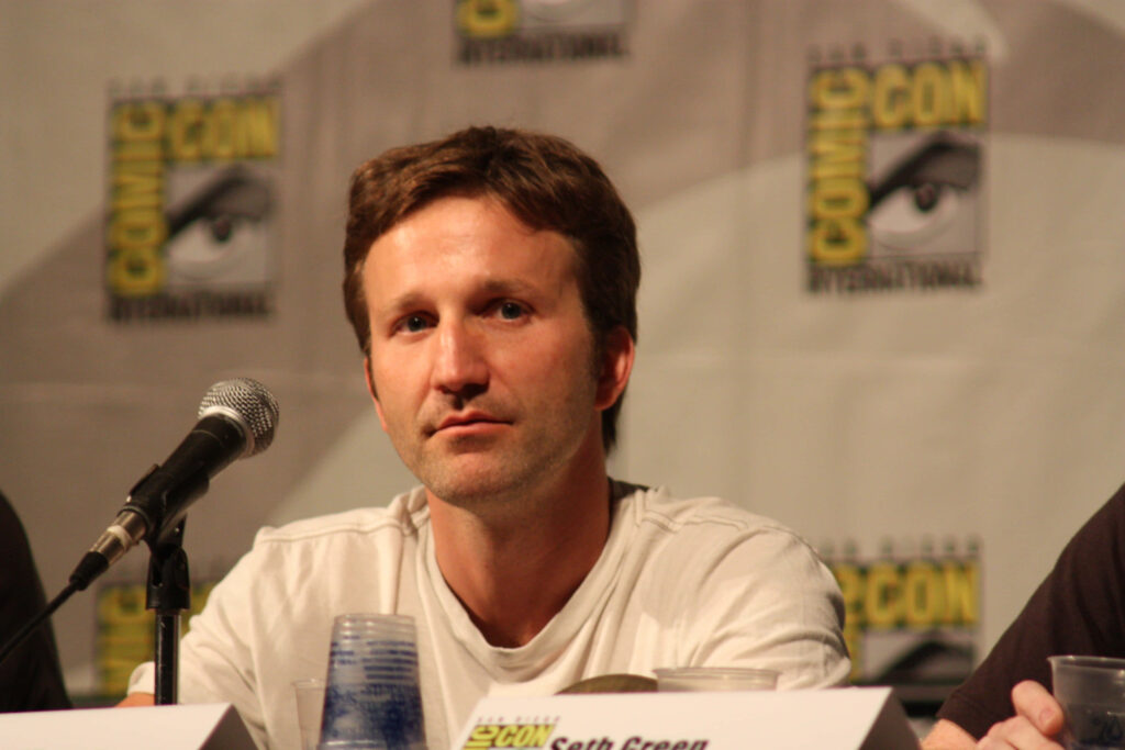 Breckin Meyer at Comic-Con panel candid photo sitting behind microphone with casual expression Wallpaper