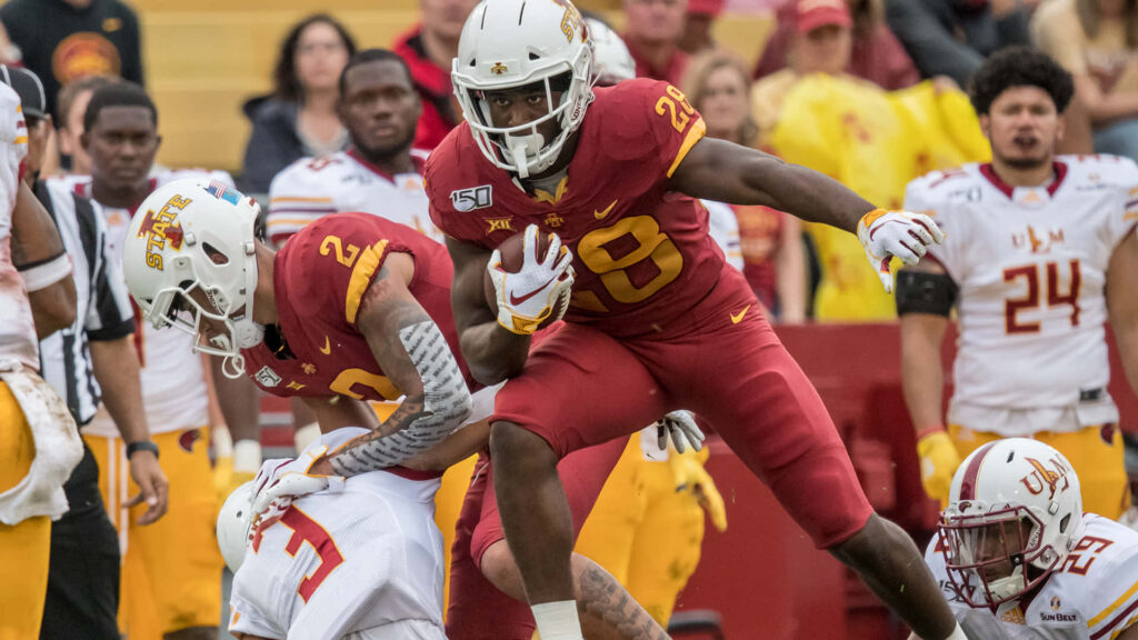 Breece Hall Iowa State Cyclones running in action evading defenders cardinal gold football wallpaper