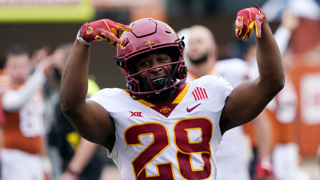 Breece Hall Iowa State Cyclones celebrating in number 28 jersey with vibrant cardinal gold background Wallpaper