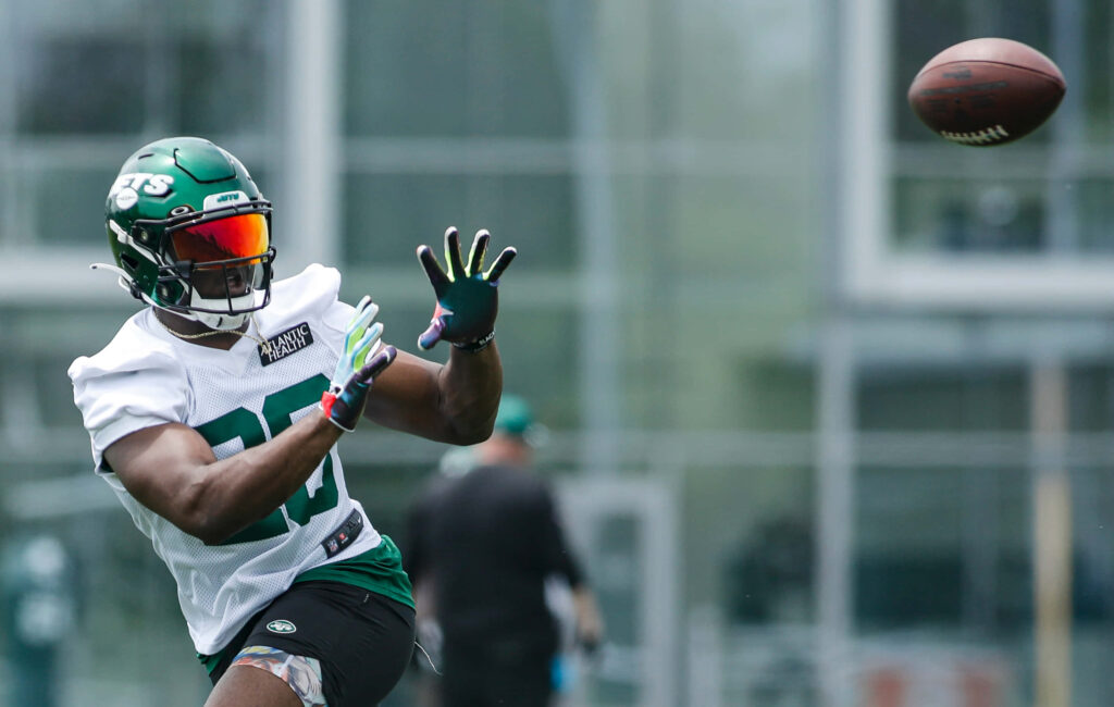 Breece Hall in New York Jets uniform mid-action catching football intense training wallpaper