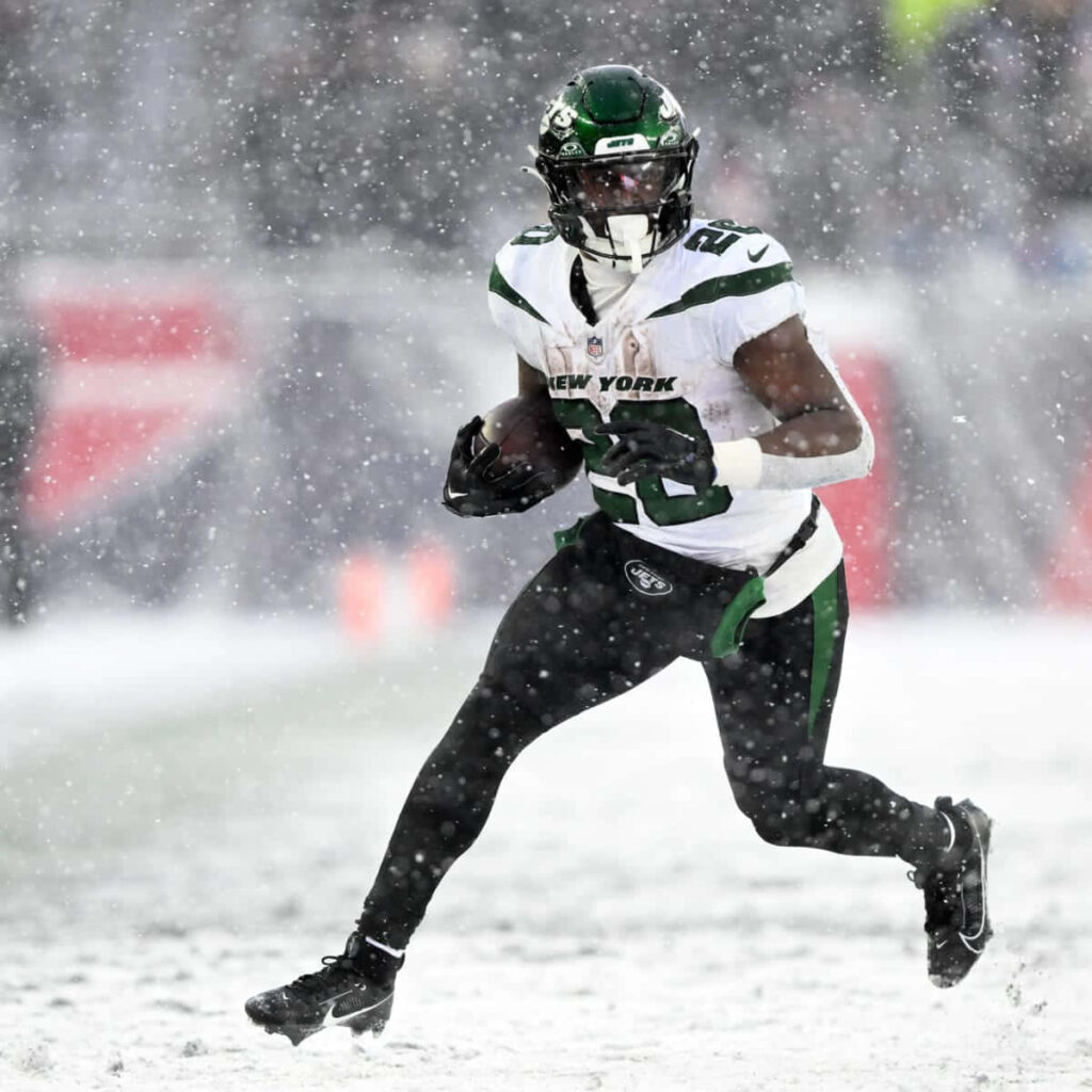 Breece Hall New York Jets action snowy game wallpaper intense winter football energy green white