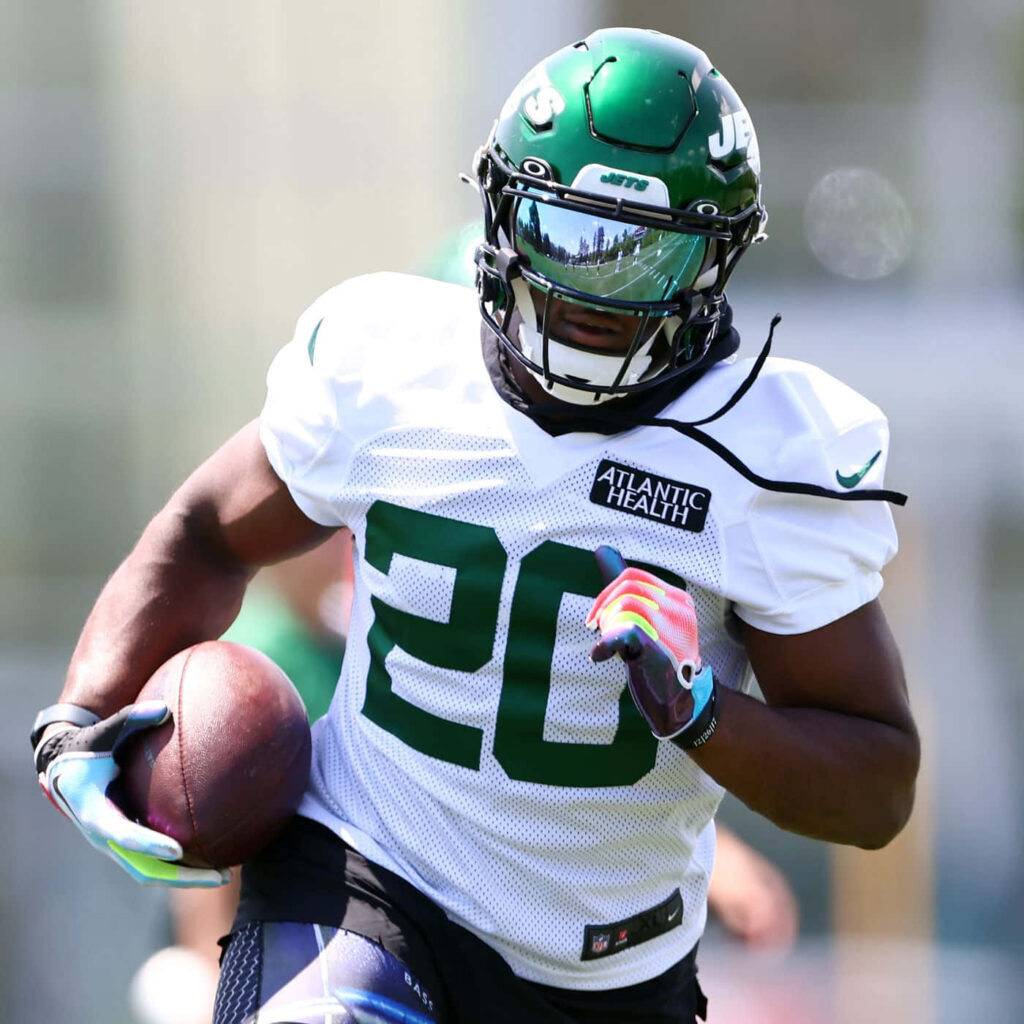 Breece Hall New York Jets intense practice wallpaper football player full gear sunlight reflections
