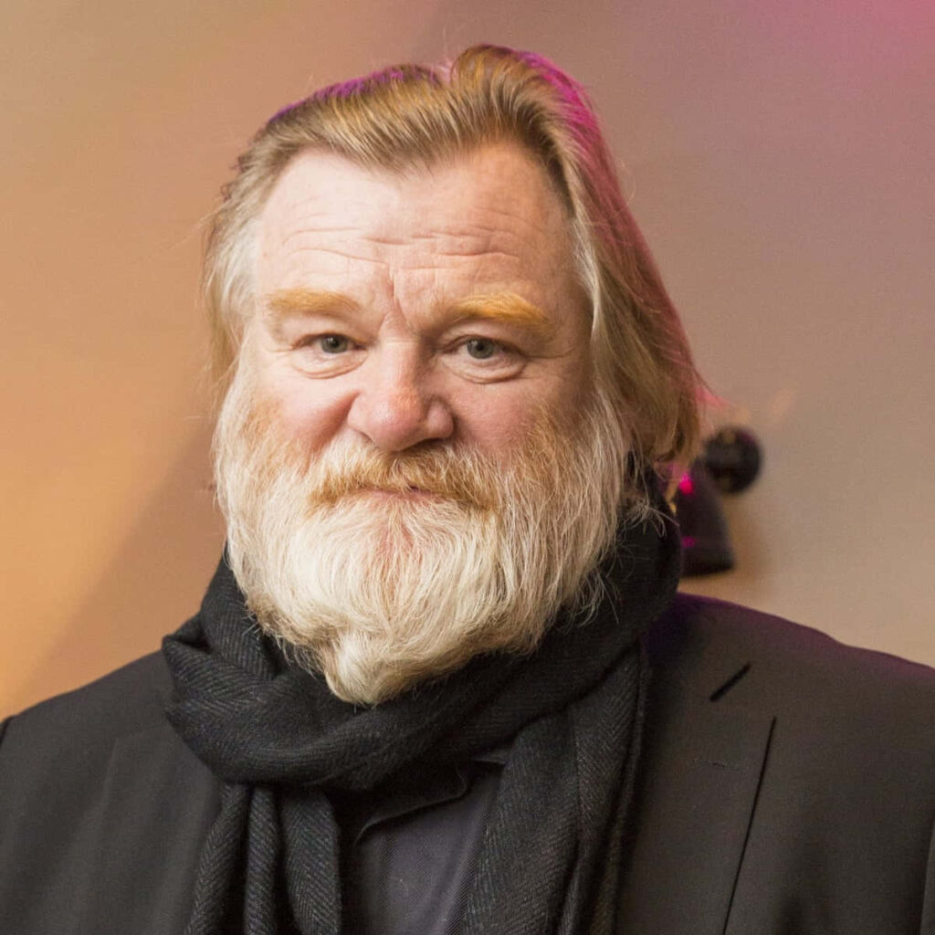 Brendan Gleeson portrait wallpaper with distinguished beard black outfit warm purple background