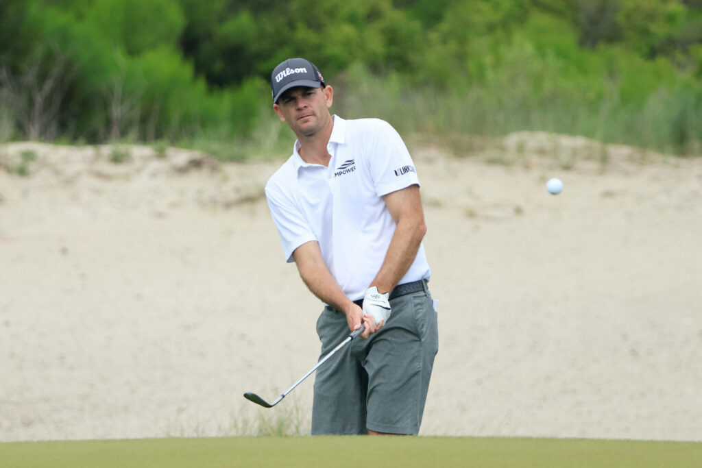 Brendan Steele mid chip shot on lush golf course with sand dunes dynamic golf sports wallpaper