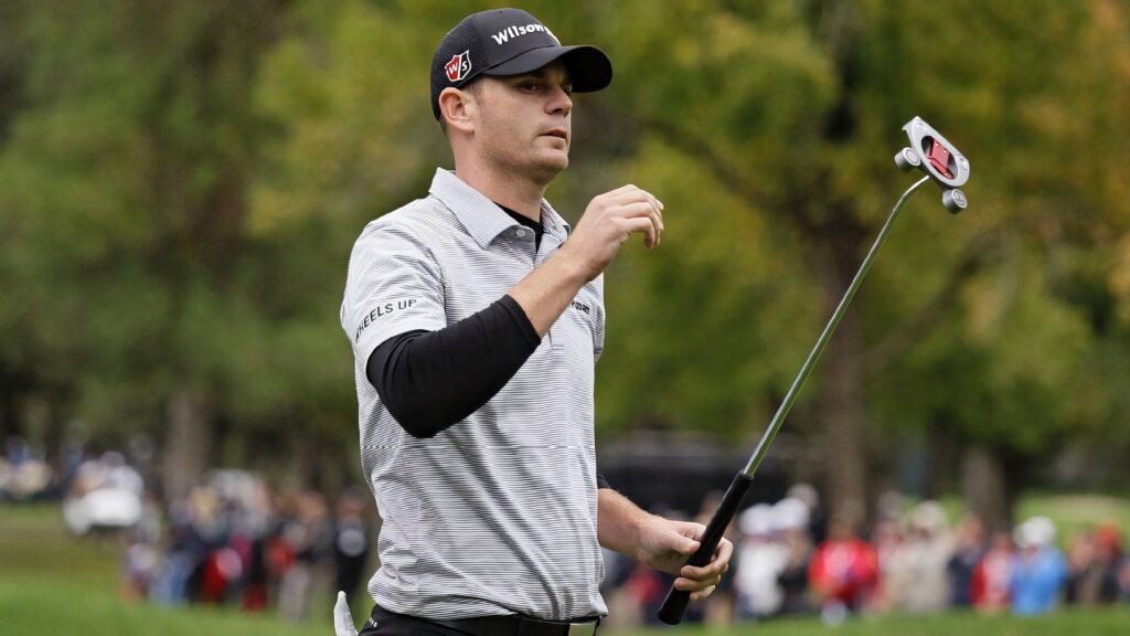 Brendan Steele raising hand on golf course wearing striped shirt and black cap vibrant sports wallpaper