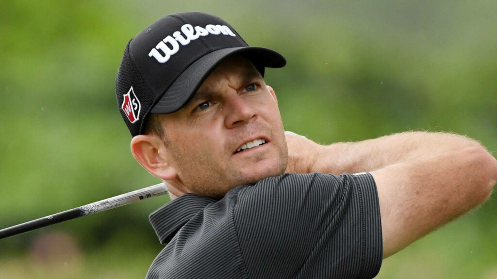Brendan Steele mid swing closeup golf wallpaper vivid green background focused expression