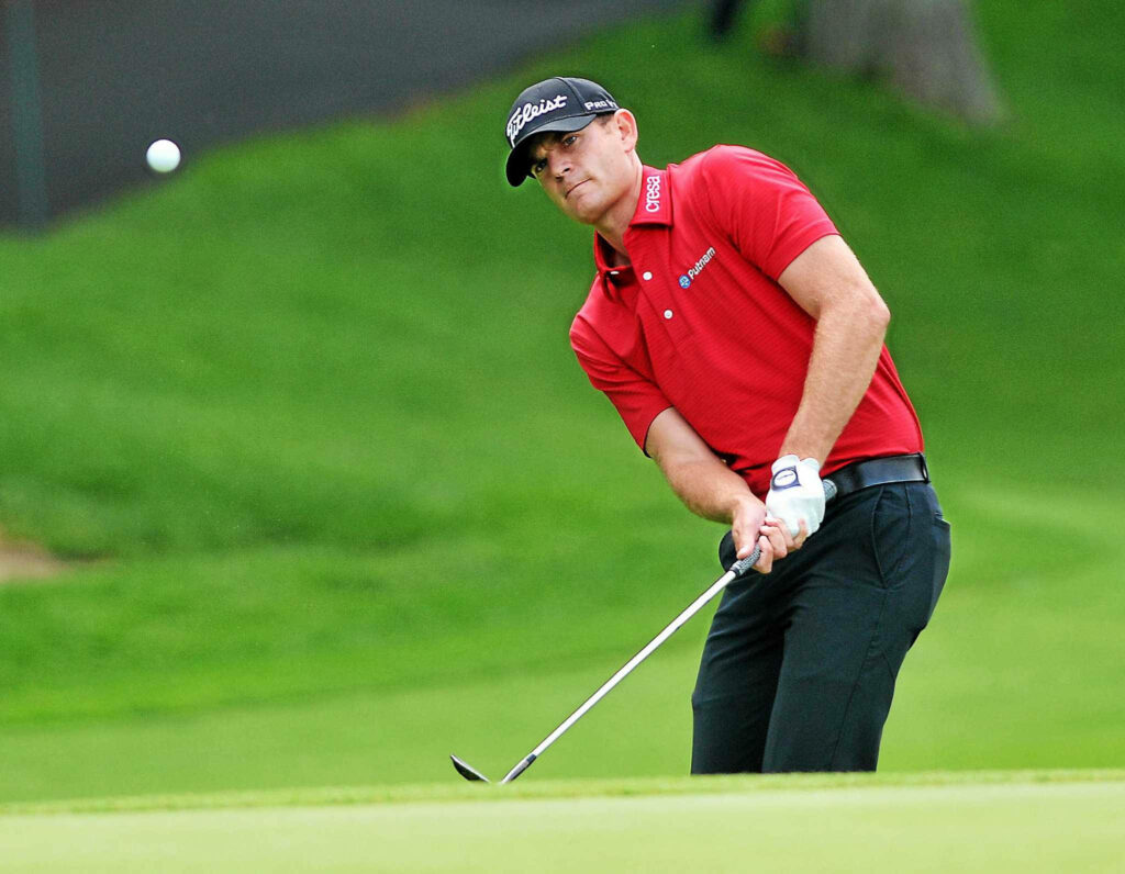 Brendan Steele focused on precision chip shot on lush hillside golf course wallpaper background
