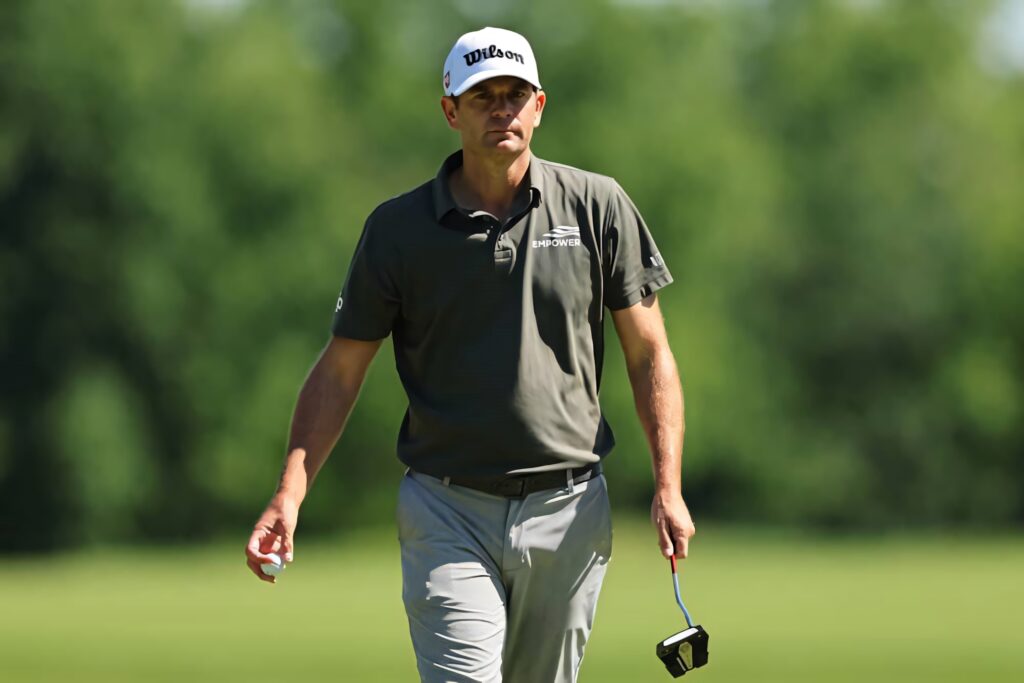 Brendan Steele walking on green golf course in Wilson cap and golf attire holding putter outdoors Wallpaper