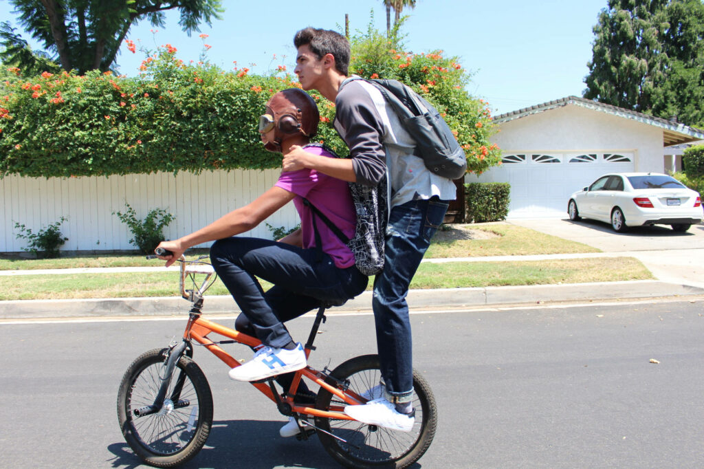 Brent Rivera balancing on BMX bike with friend on suburban street summer friendship wallpaper