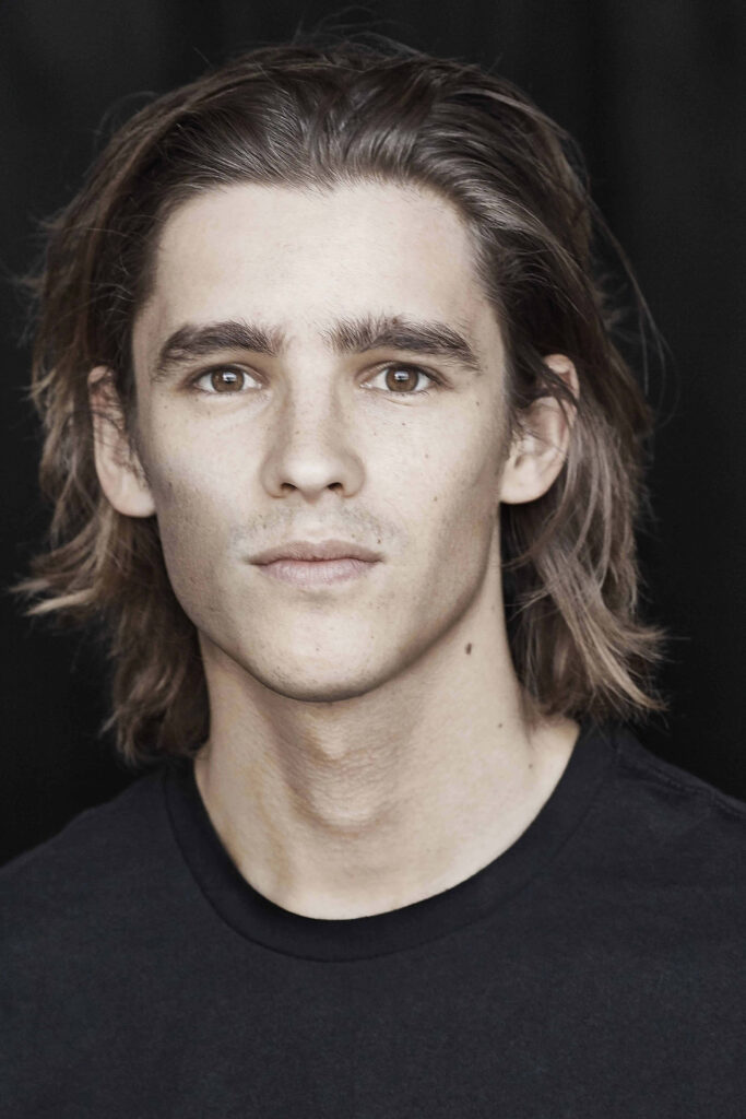 Brenton Thwaites close-up portrait wallpaper with natural light and dark background for fans