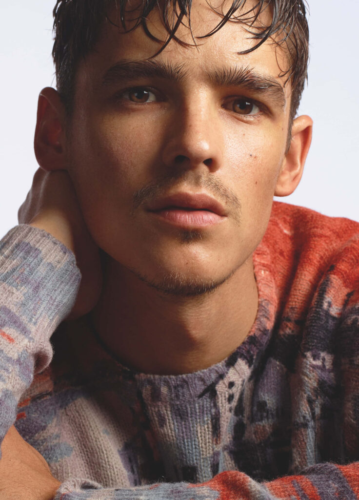 Brenton Thwaites close-up portrait in patterned knit sweater warm tones high-resolution wallpaper