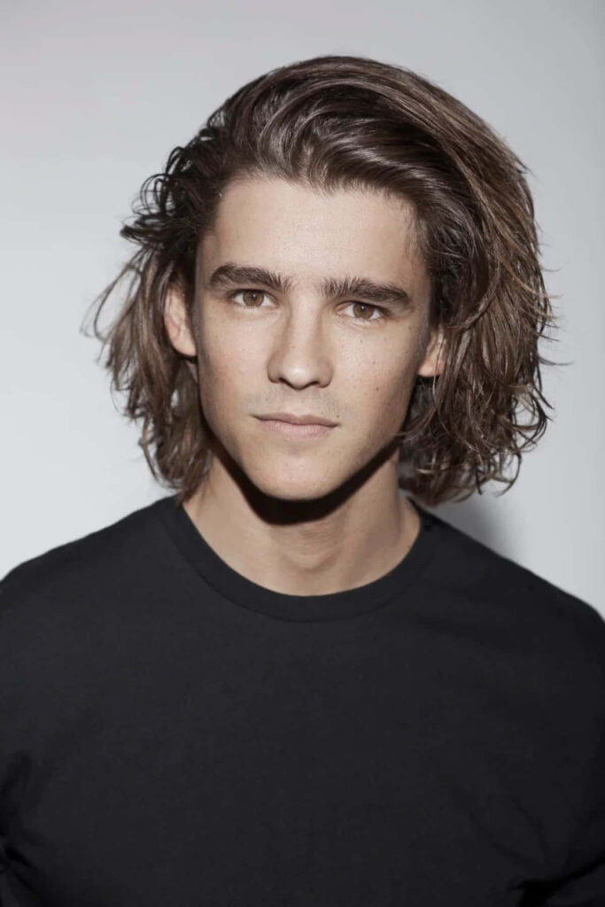 Brenton Thwaites portrait with tousled hair natural lighting clean background modern celebrity wallpaper