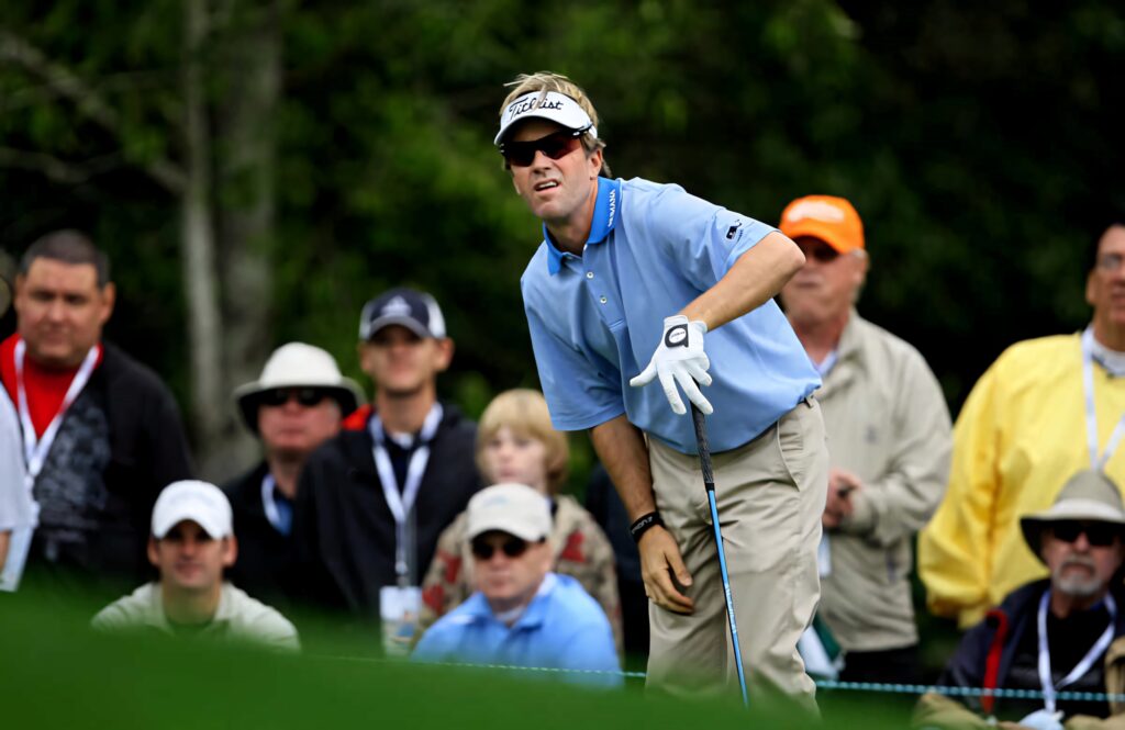 Brett Quigley focused on golf shot during tournament lush green background high resolution wallpaper