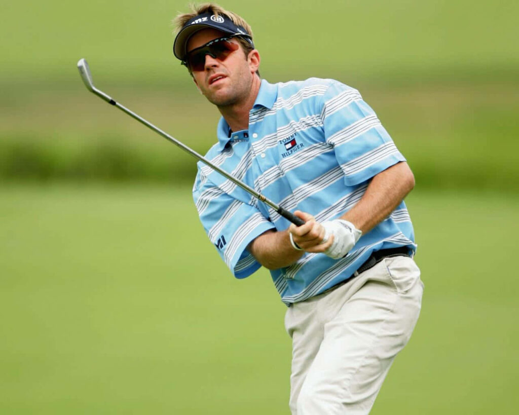 Brett Quigley focused golf swing in striped shirt vibrant green background high resolution action shot Wallpaper