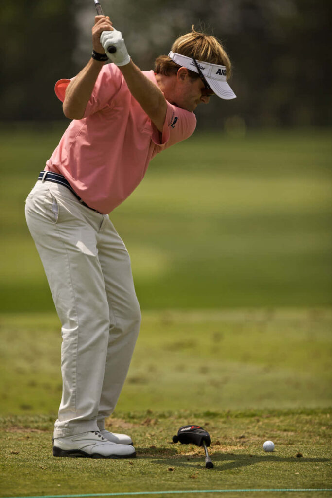 Brett Quigley focused pre-swing golf portrait on green course in pink shirt high-resolution wallpaper