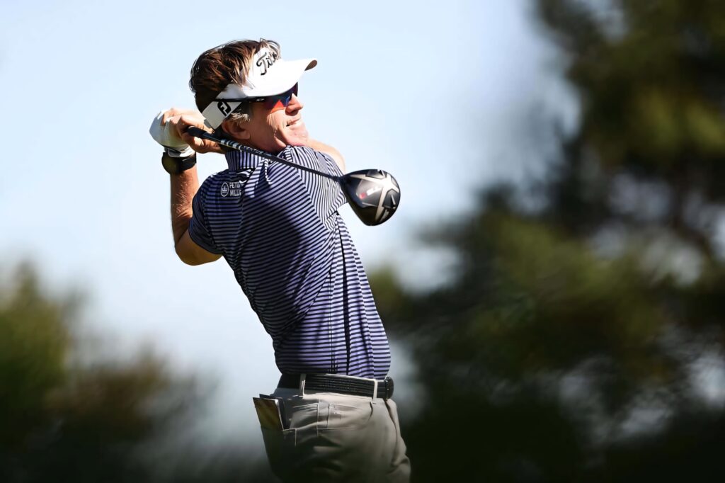 Brett Quigley mid-swing on sunlit golf course focused professional golfer wallpaper background
