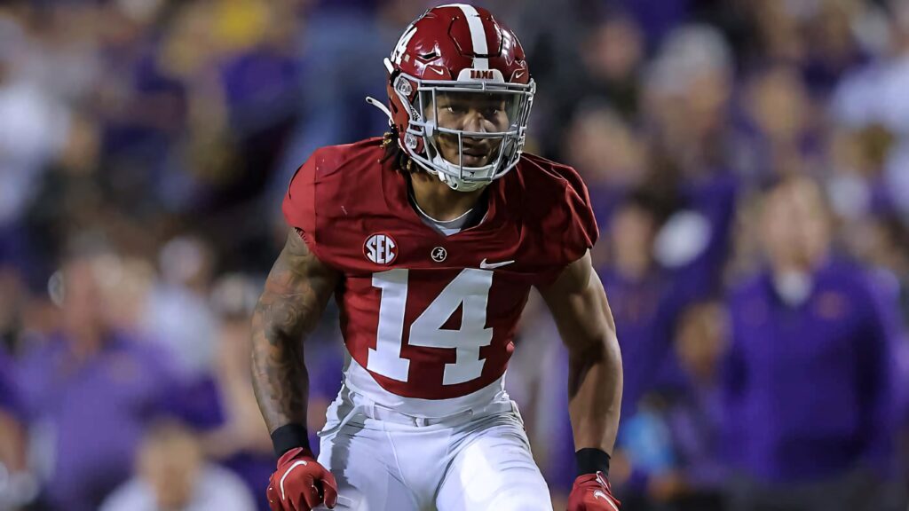Brian Branch Alabama Crimson Tide football player in action maroon white uniform stadium background Wallpaper