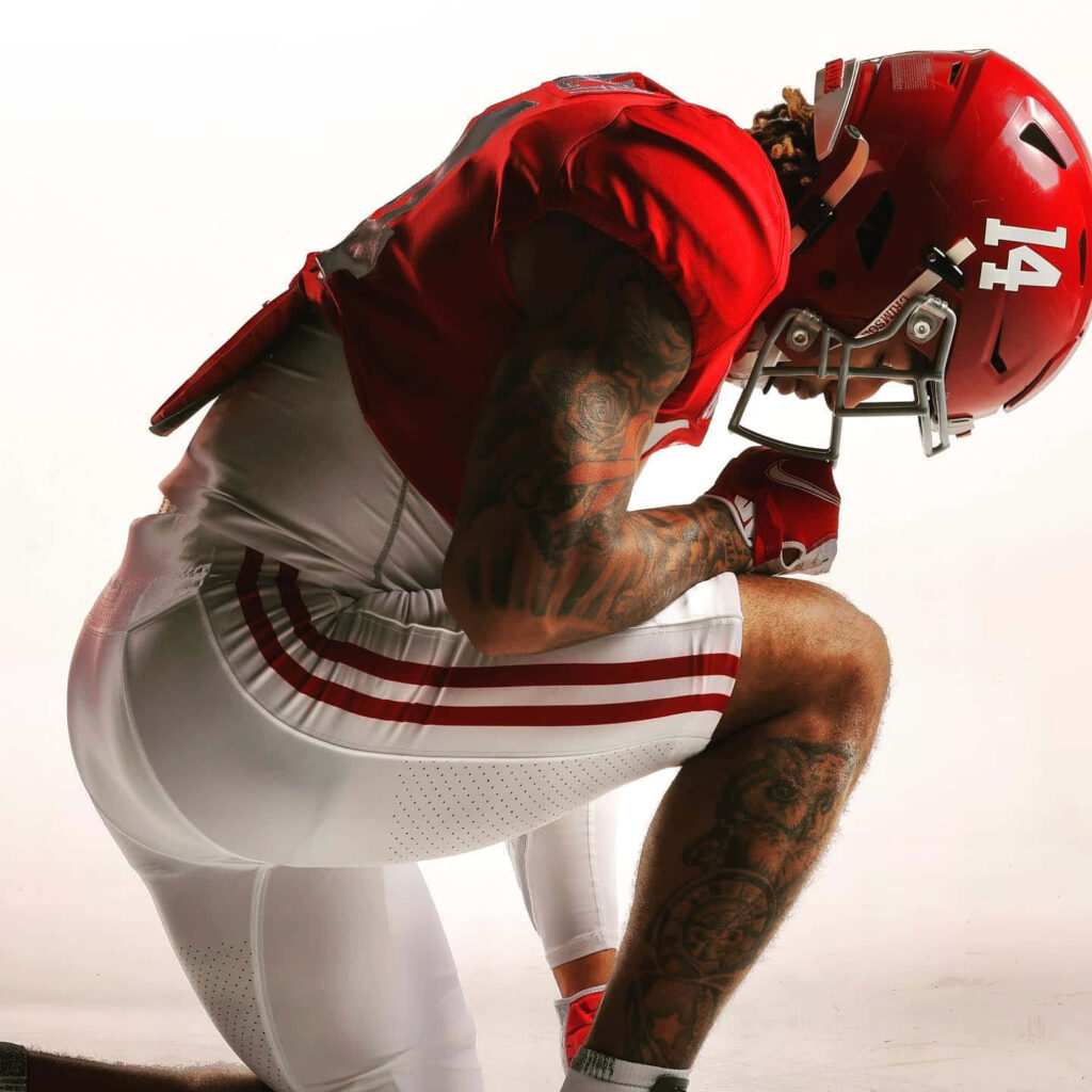 Brian Branch football player kneeling side profile red white uniform detailed tattoos intense energy Wallpaper
