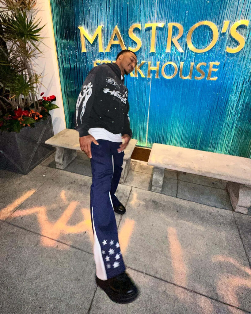 Brian Branch confident pose in star pants and graphic jacket outside Mastro's Steakhouse wallpaper