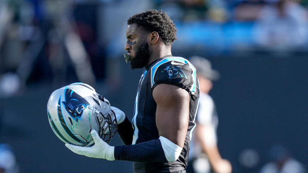 Brian Burns Carolina Panthers in black and blue uniform holding helmet high resolution NFL wallpaper