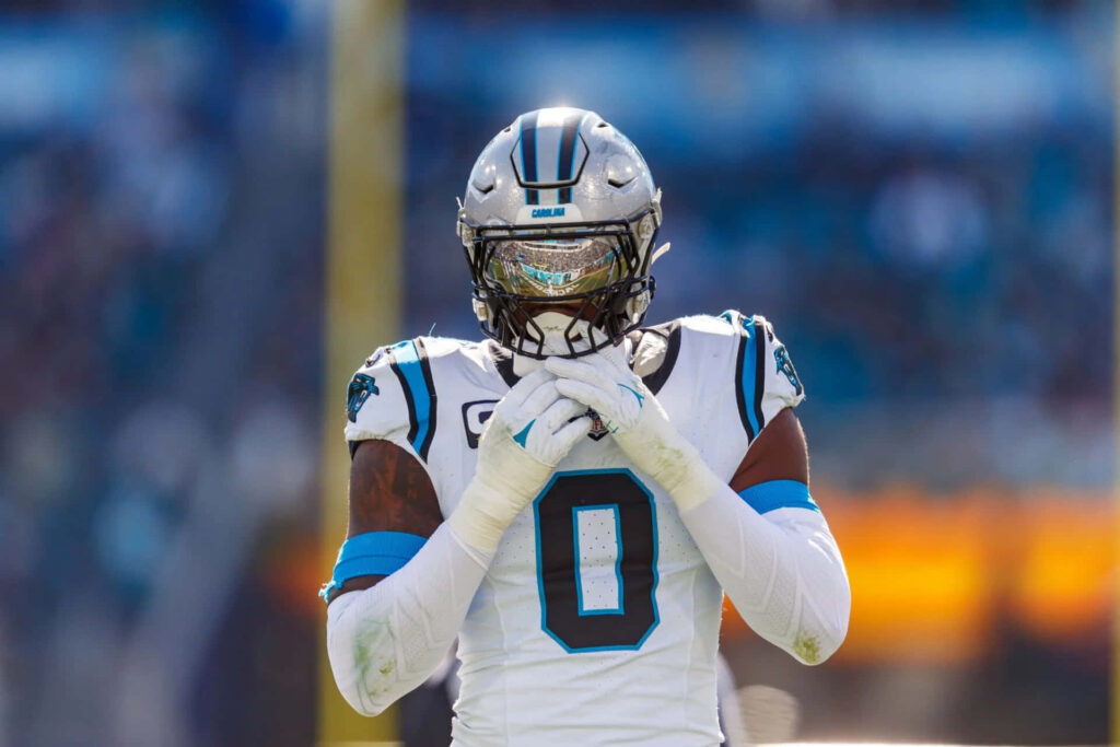 Brian Burns Carolina Panthers in number 0 jersey with silver helmet on vivid football field background Wallpaper