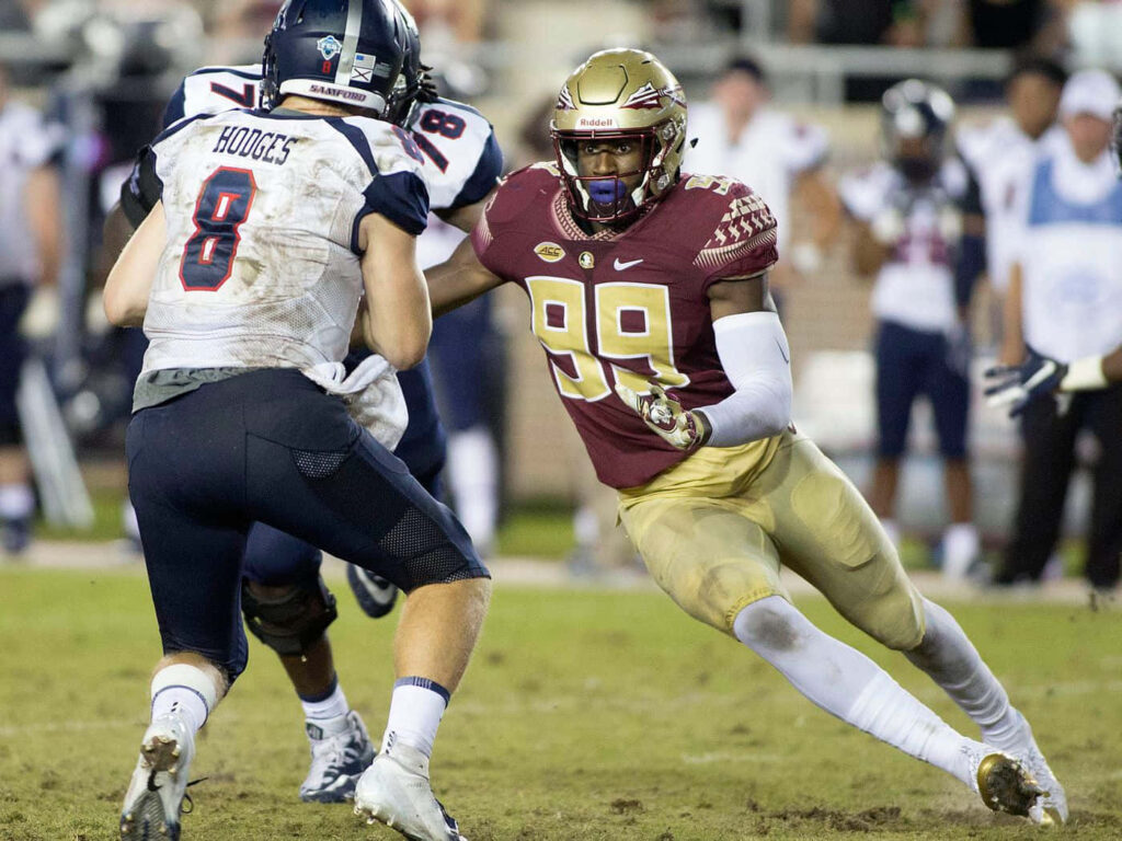 Brian Burns football action charging opponent maroon gold uniform intense athleticism wallpaper