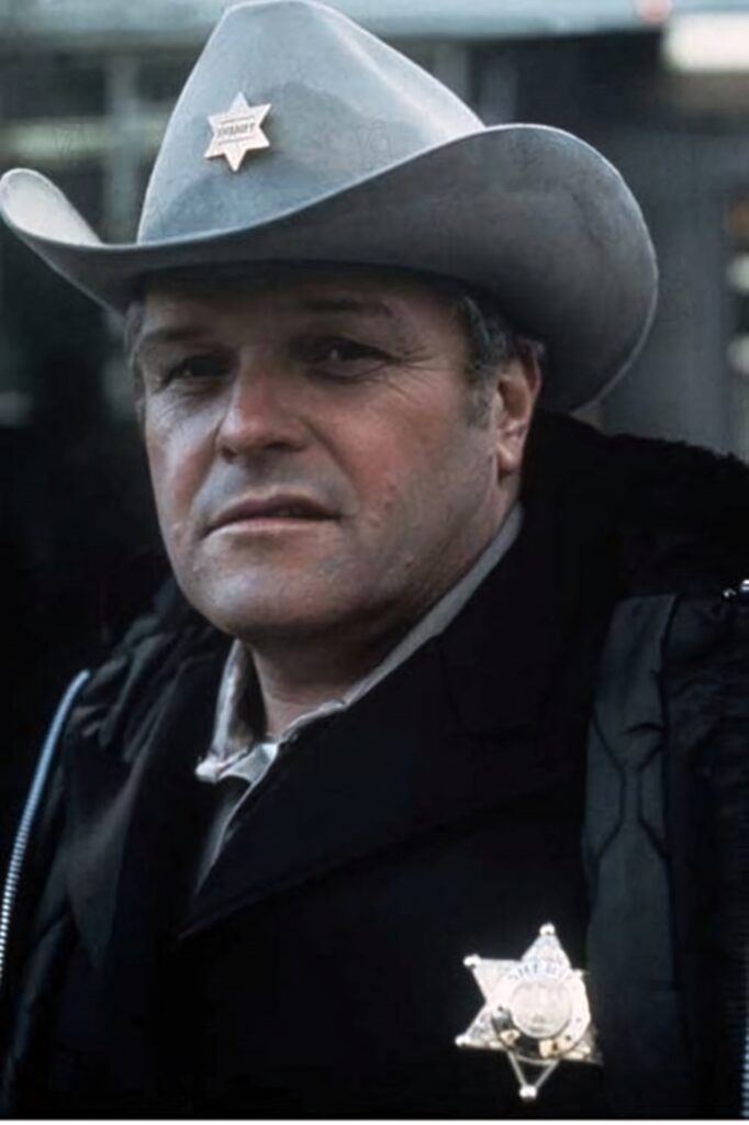 Brian Dennehy as classic Western sheriff in cowboy costume with badge and wide-brimmed hat wallpaper
