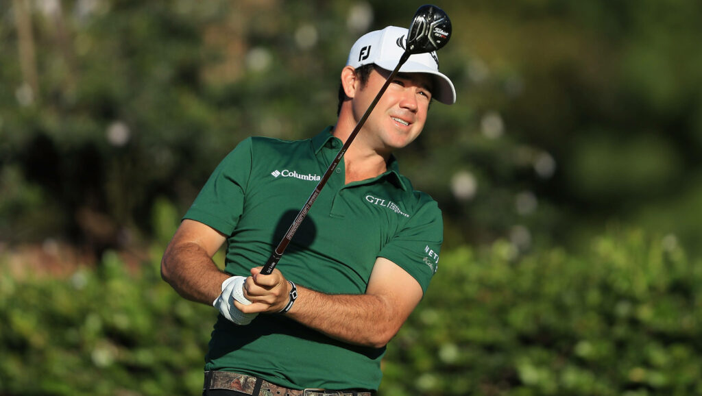 Brian Harman golfing in green Columbia polo with driver on lush green course high resolution wallpaper