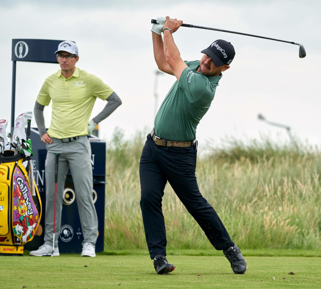 Brian Harman mid golf swing on green course with overcast sky showcasing athletic technique Wallpaper
