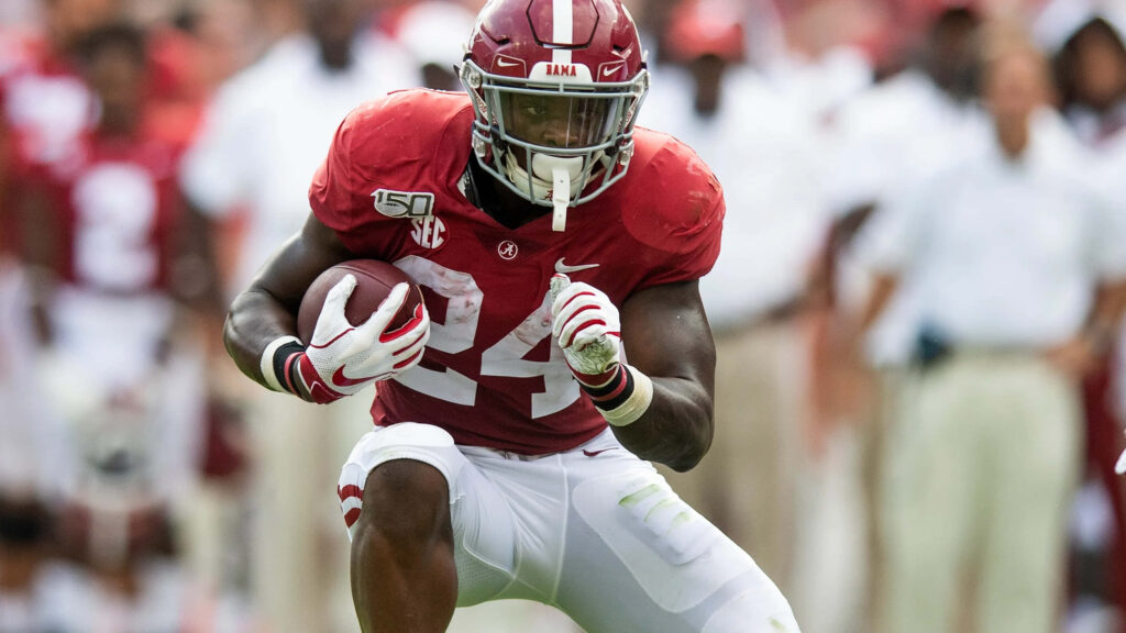Brian Robinson Jr Alabama Crimson Tide running back sprinting with football high resolution action Wallpaper