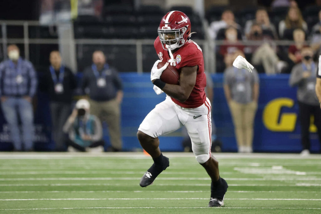 Brian Robinson Jr Alabama Running Back in crimson jersey sprinting on football field high energy action Wallpaper