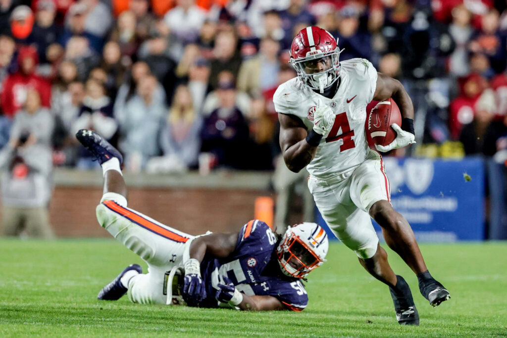 Brian Robinson Jr evading tackle in intense football game showing agility power action shot Wallpaper