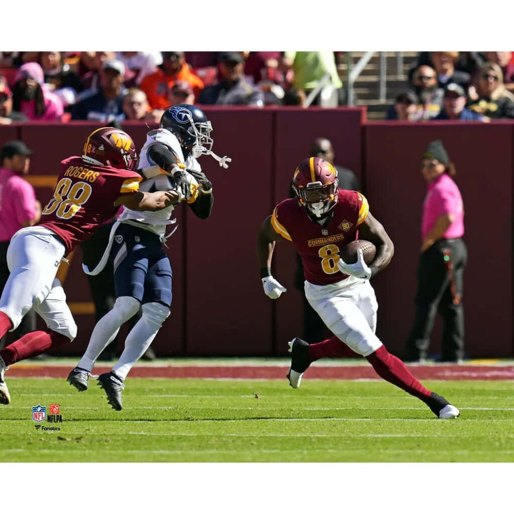 Brian Robinson Jr powerful run Commanders vs Titans NFL action vibrant burgundy gold uniforms Wallpaper