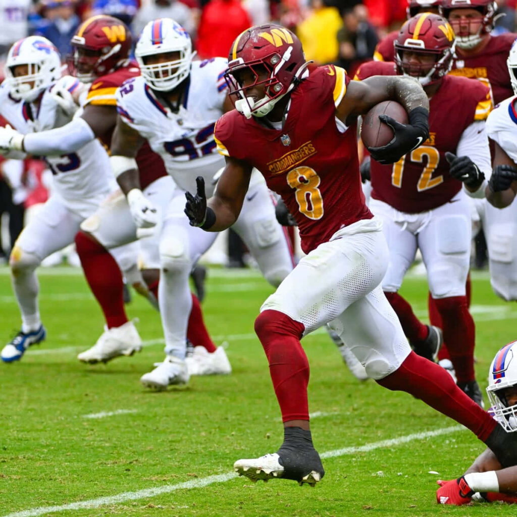 Brian Robinson Jr running fast in Washington Commanders uniform football action wallpaper background