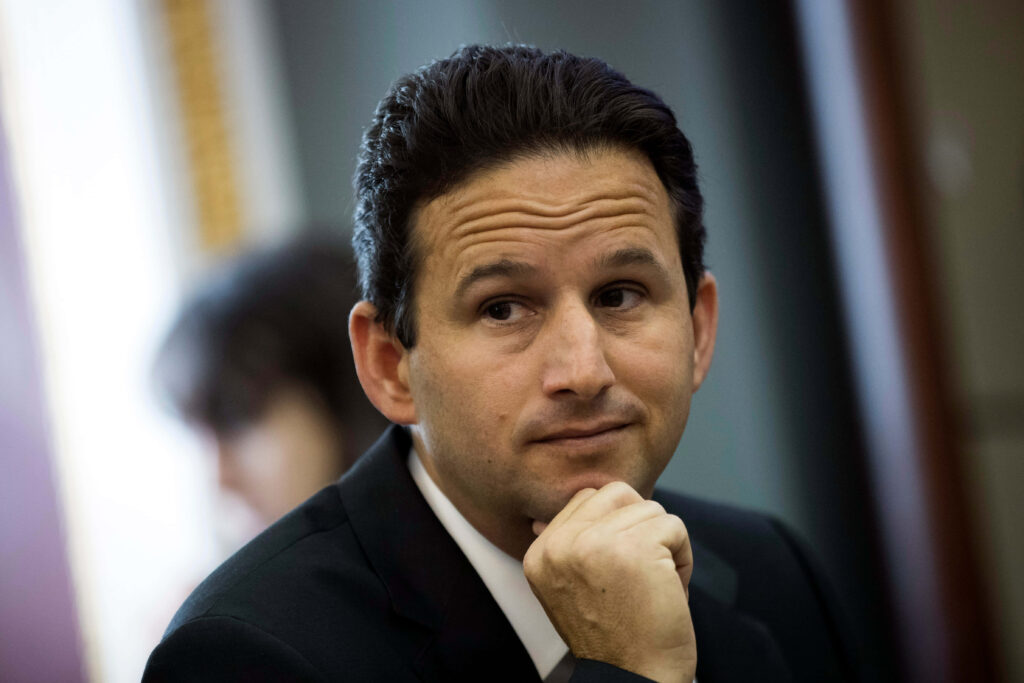 Senator Brian Schatz in formal attire thoughtfully engaged during congressional session wallpaper