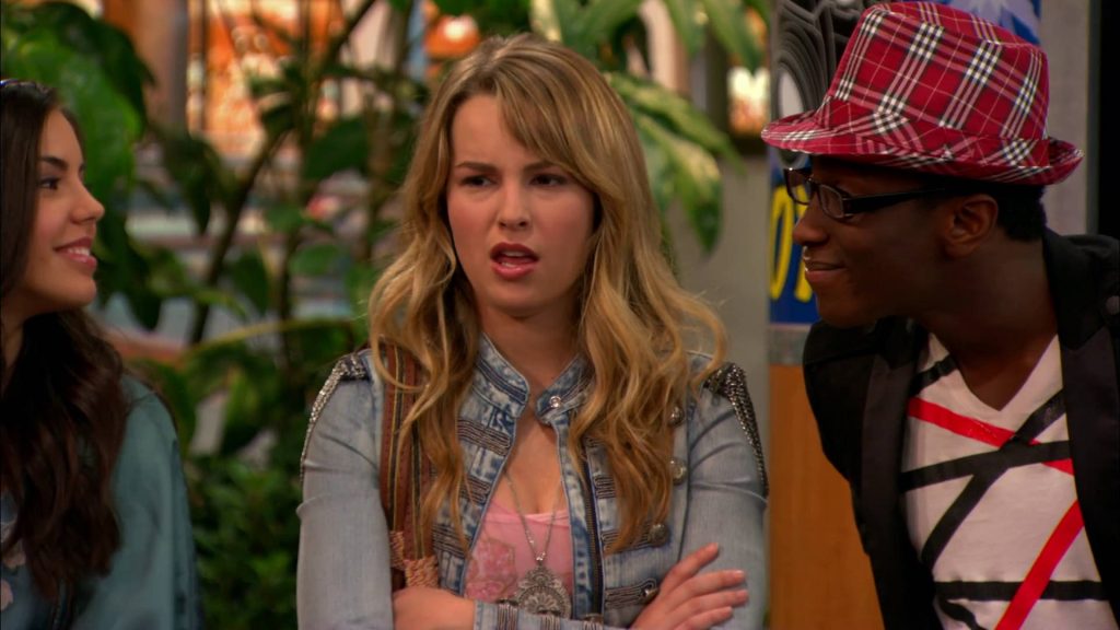 Bridgit Mendler skeptical with Victoria Justice and Leon Thomas III red plaid hat sitcom wallpaper background