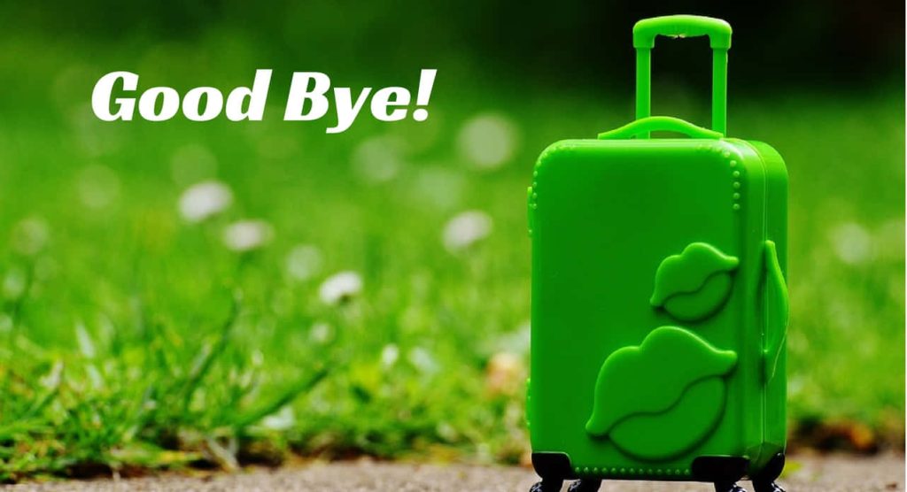 Bright lime green miniature suitcase with embossed kiss marks and Good Bye text outdoors Wallpaper