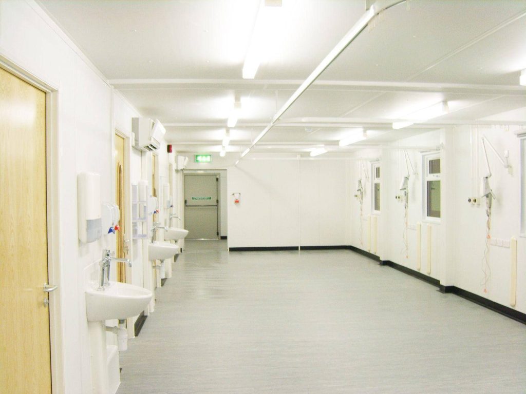 Bright modern hospital hallway wallpaper with sterile white walls hand-washing stations and lighting